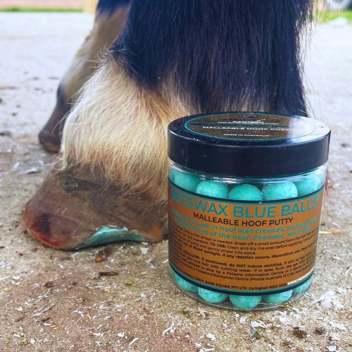 Jar of Beeswax Blue Balls malleable hoof putty label beside a horse's hoof
